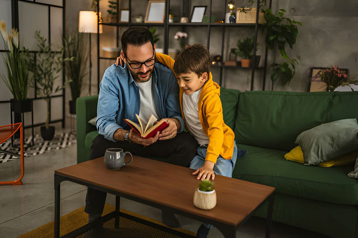 Père et fils lisent un livre et s'amusent tout en passant du temps ensemble